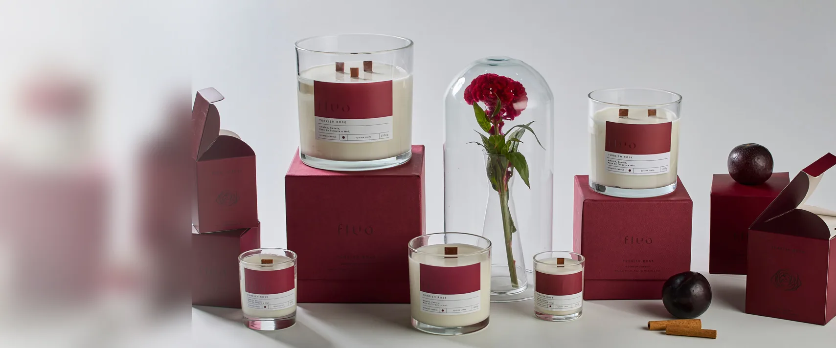 Linha de embalagens cartonadas em tom vinho com velas artesanais, produzidas pela Prima Stampa