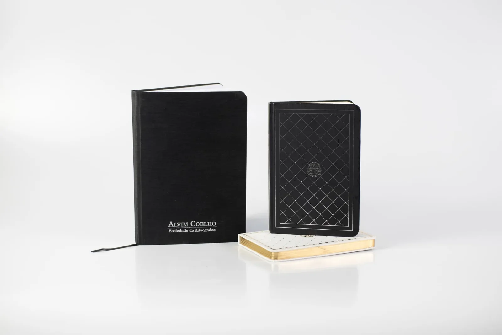 Cadernos capa dura em preto com hot stamping prateado e caderneta com corte dourado