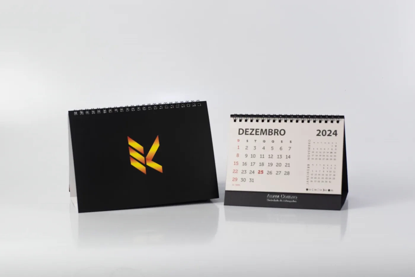 Par de calendários de mesa: capa preta com logotipo em degradê e miolo mensal impresso em duas cores