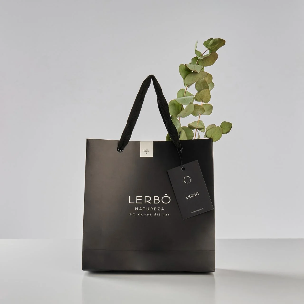 Sacola preta da Lerbô Natureza com tag personalizada e ramo de eucalipto