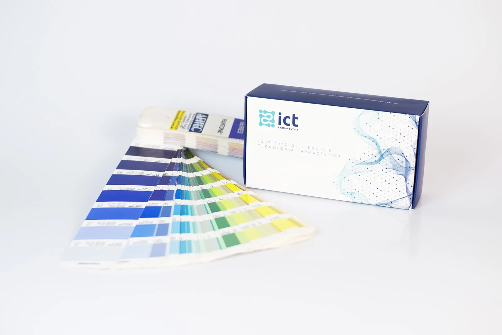 Escala Pantone aberta ao lado de cartucho impresso para conferência de cor